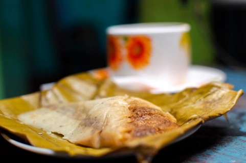 Stuffed tamale served on wooden table