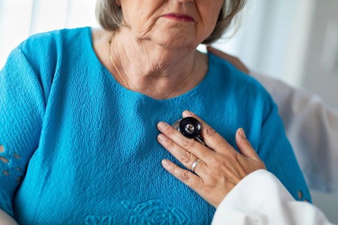 Female doctor checking the heart with stethoscope of senior adult woman