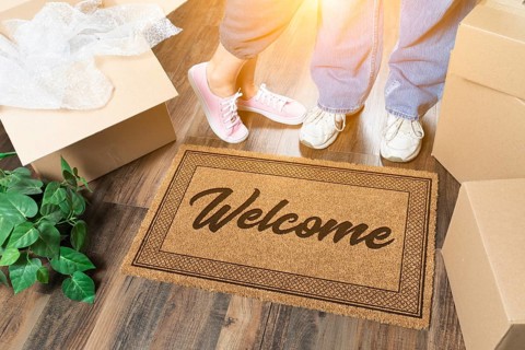 Man and woman standing near welcome mat