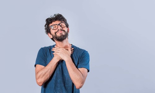 Attractive friendly and positive looking young man with a charming sincere smile feeling grateful