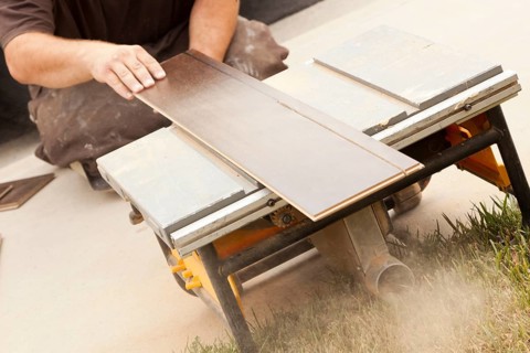 Contractor using circular saw cutting of new laminate flooring renovation
