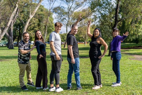 Multi ethnic family group walking arm in arm in a park