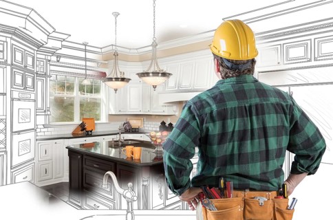 Male contractor with hard hat and tool belt looking at custom kitchen drawing photo combination on white