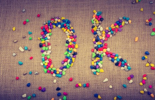 Colorful pebbles form the word OK on canvas ground