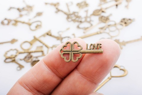 Hand and retro style metal keys on a white background