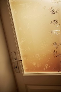 Verschlossene Glastuere in einem Wohnhaus mit Tuergriff und Tuerschluessel