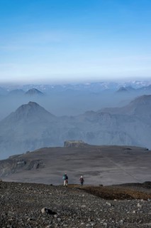 Two hikers on trail through volcanic landscape