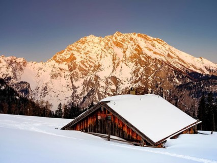 Snowy Priesbergalm in front of Watzmann east face at sunrise