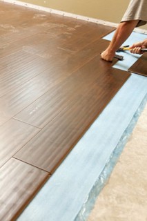 Man installing new laminate wood flooring abstract