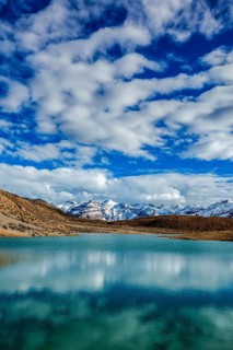 Himalayas mountains reflecting in mountain lake Dhankar Lake. Spiti Valley