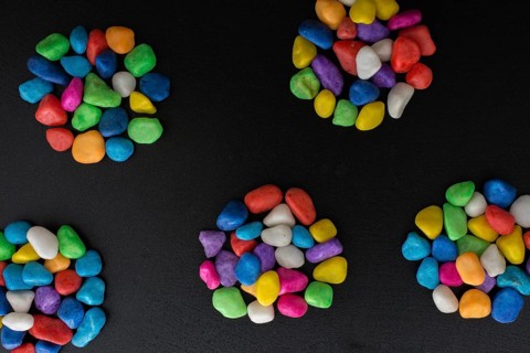 Pile of little colorful pebbles on black background