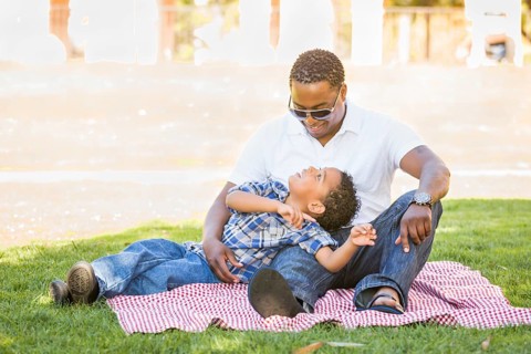 Happy african american father and mixed-race son playing at the park