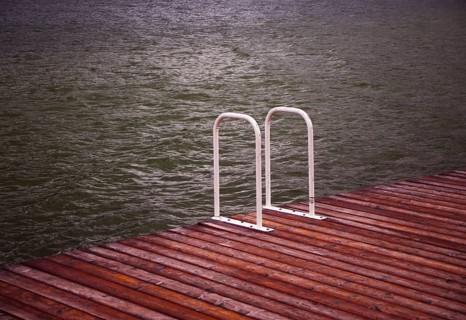 Verlassener Badesteg mit Leiter bei Regenwetter