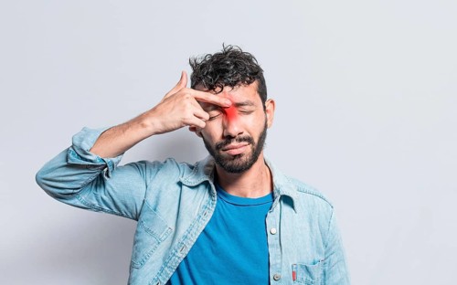 Young man with pain touching nose. A person with nasal bridge pain