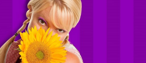 Beautiful girl holding yellow sunflower against purple striped background