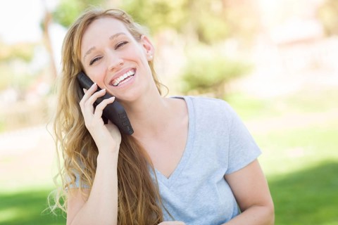 Young adult woman outdoors talking on her smart phone