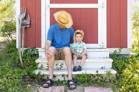 Playful young caucasian father and mixed-race chinese son wearing cowboy hats