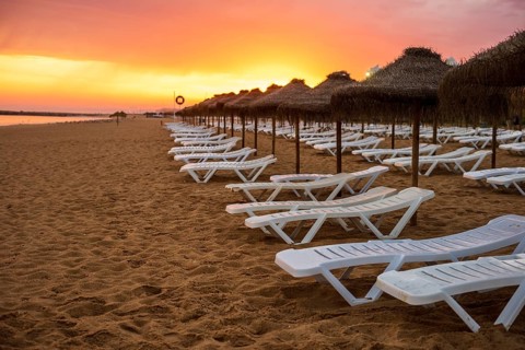 Beautiful colorful sunset over sun beds and umbrellas in Vilamoura