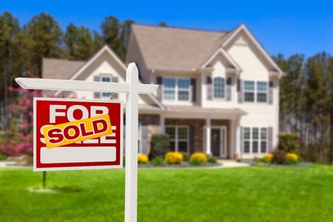 Sold home for sale real estate sign and beautiful new house