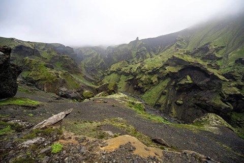 View into rugged moss-covered canyon with tufa rock formations