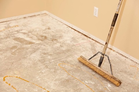 Blank concrete house floor with broom ready for flooring installation