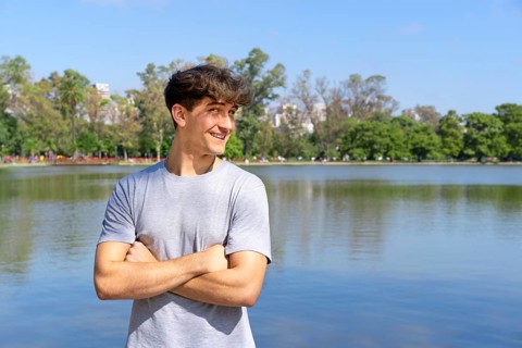 Portrait of confident young blond man with crossed arms looking at camera