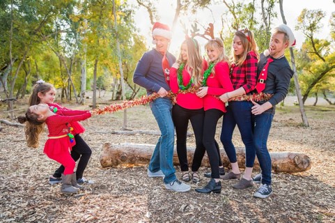 mixed-race family portrait with children tying up group with tinsel rope