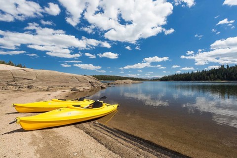 Pair of yellow kayaks on a beautiful mountain lake shore