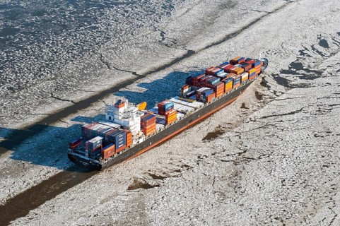 Container ship on the Elbe in ice