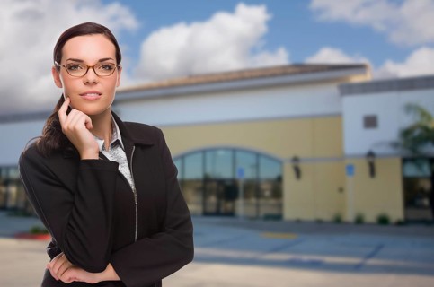 Attractive serious mixed-race woman in front of vacant commercial retail building