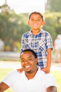 Happy african american father and mixed-race son playing at the park