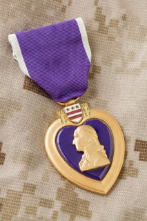 Purple heart medal laying on military fatigues