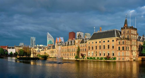 Panorama of the Binnenhof House of Parliament and the Hofvijver lake with downtown skyscrapers in background