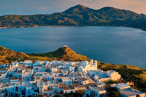 View of Plaka village on Milos island with traditional greek white houses on sunset