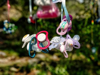 Colourful discarded dummies hanging on a tree