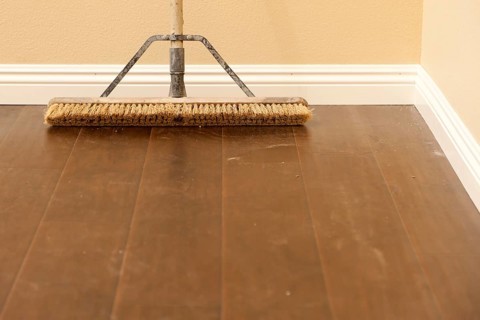 Push broom on a newly installed laminate floor and new baseboards