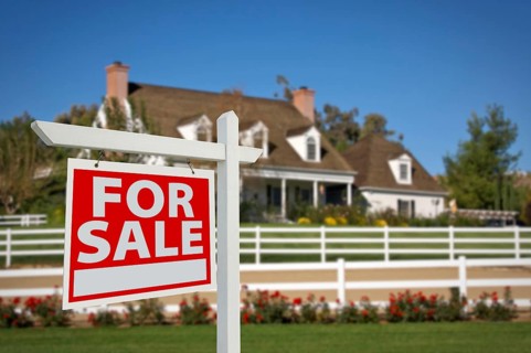 Home for sale real estate sign in front of new house