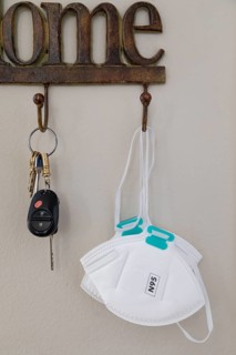 Home key hanger rack next to door with keys and medical face mask during coronavirus pandemic