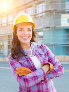 Portrait of young female construction worker wearing gloves