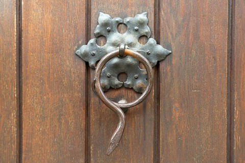 Snake figure as a door knocker on the door of a parish