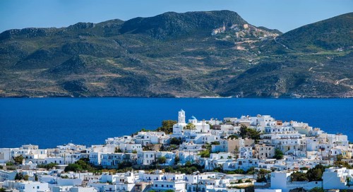 Panorama of Plaka village with traditional Greek church white painted Greek houses and ocean coast