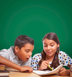 Blank chalk board behind hispanic boy and girl having fun studying together