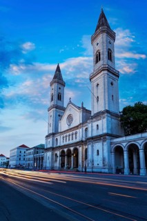 St. Ludwig's Church Ludwigskirche in the evening. Car Light Traces motion blur because of long exposure. Munich