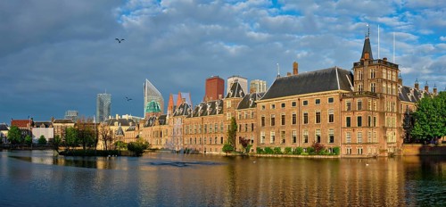 Panorama of the Binnenhof House of Parliament and the Hofvijver lake with downtown skyscrapers in background
