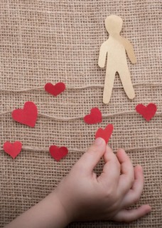 Man shape cut out of paper in hand in the view