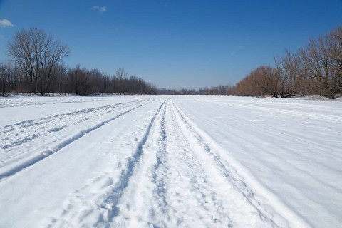Snow vehicle tracks on a frozen river surface