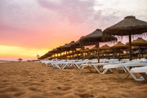 Beautiful colorful sunset over sun beds and umbrellas in Vilamoura