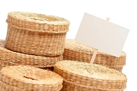 Various sized wicker baskets with blank sign isolated on white