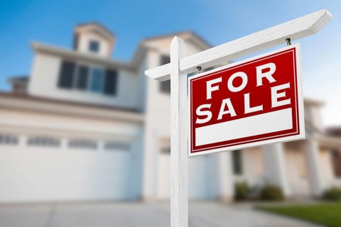 Home for sale real estate sign in front of new house