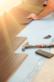 Man installing new laminate wood flooring abstract